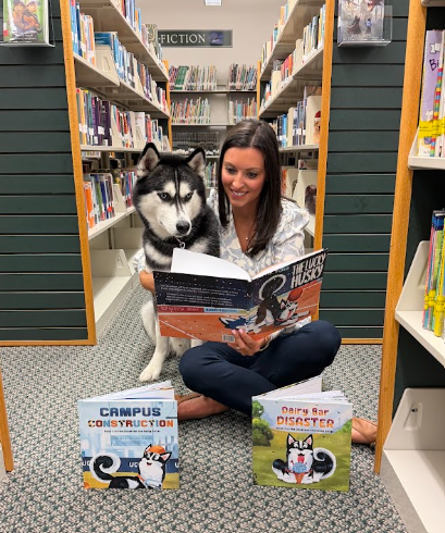 Bethany O'Brien reading The Lucky Husky with Jonathan the Husky at the library, with the other two books beside them